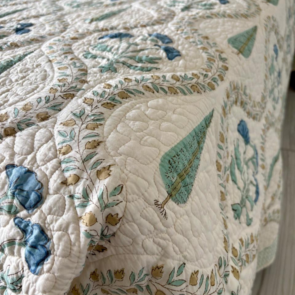 Quilt with floral and leaf patterns on a table