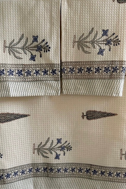 Set of towels with floral and carrot patterns on a marble background