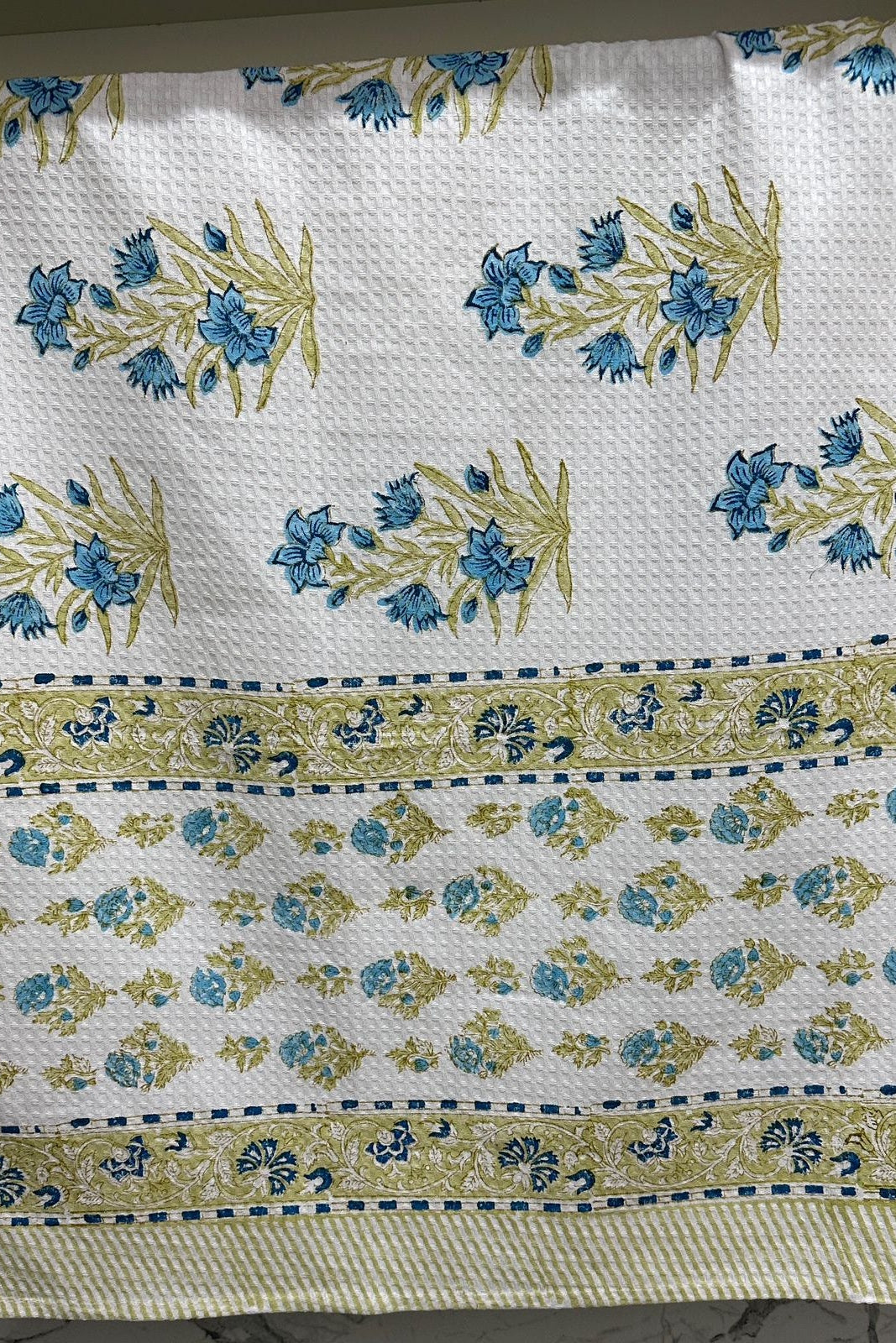 Patterned fabric with blue and green floral design on a white background