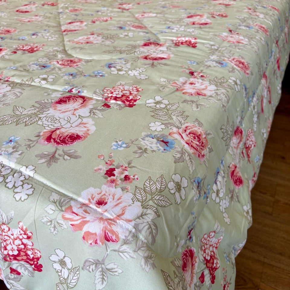Floral-patterned quilt on a bed with a wooden headboard.