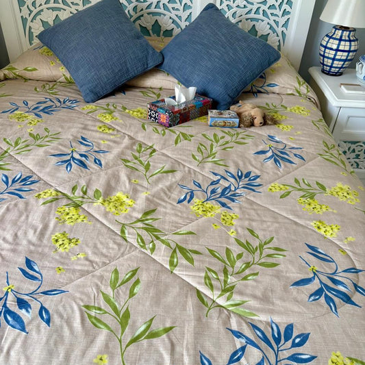 Floral patterned bedspread on a bed with decorative pillows and nightstands.