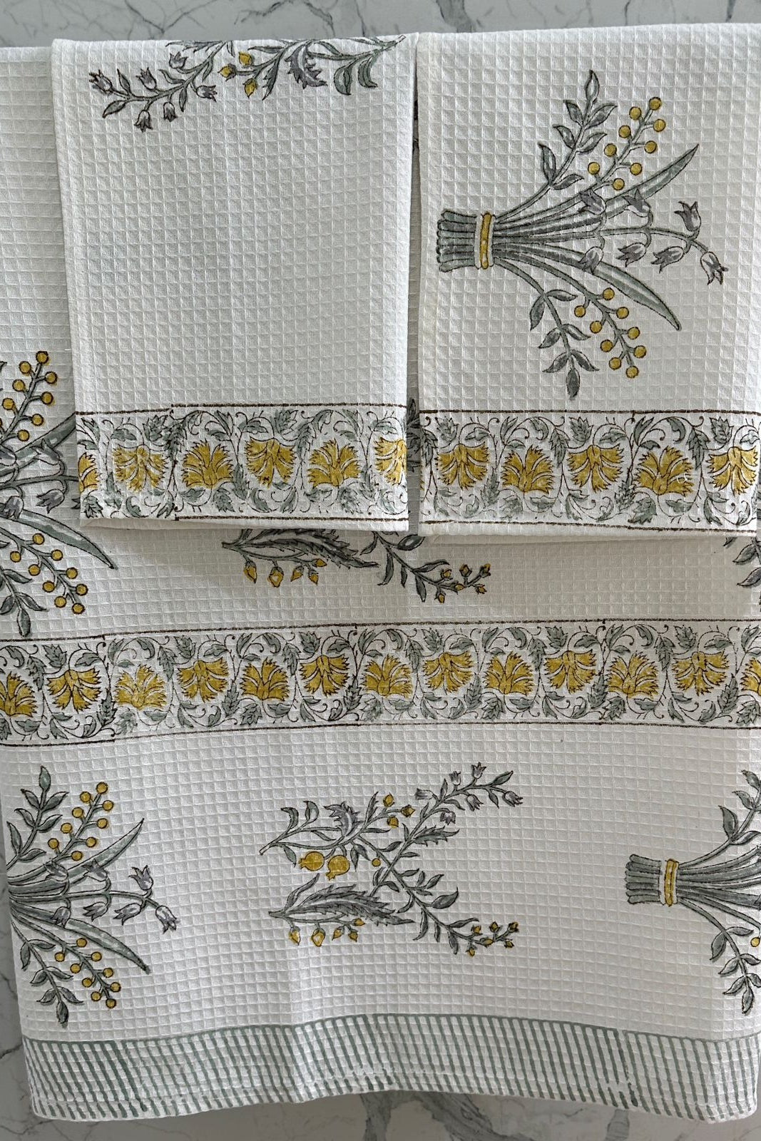 Set of decorative towels with floral patterns on a textured surface