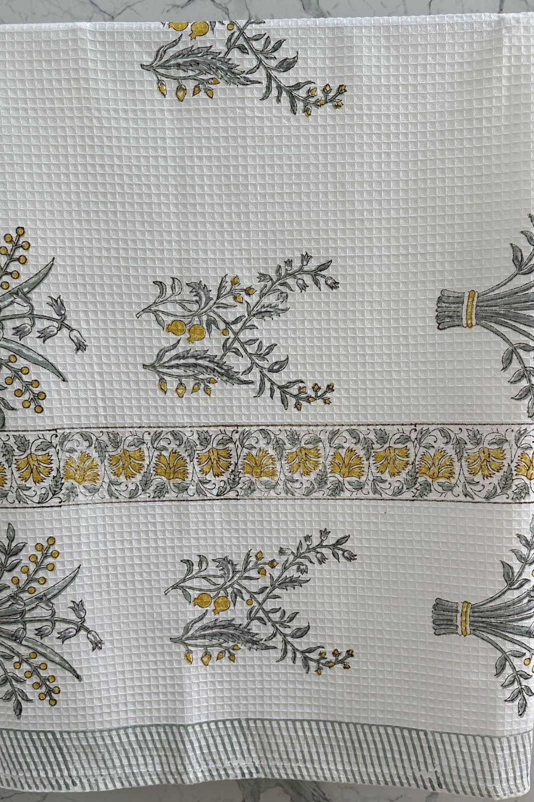 White towel with floral and geometric patterns on a textured surface