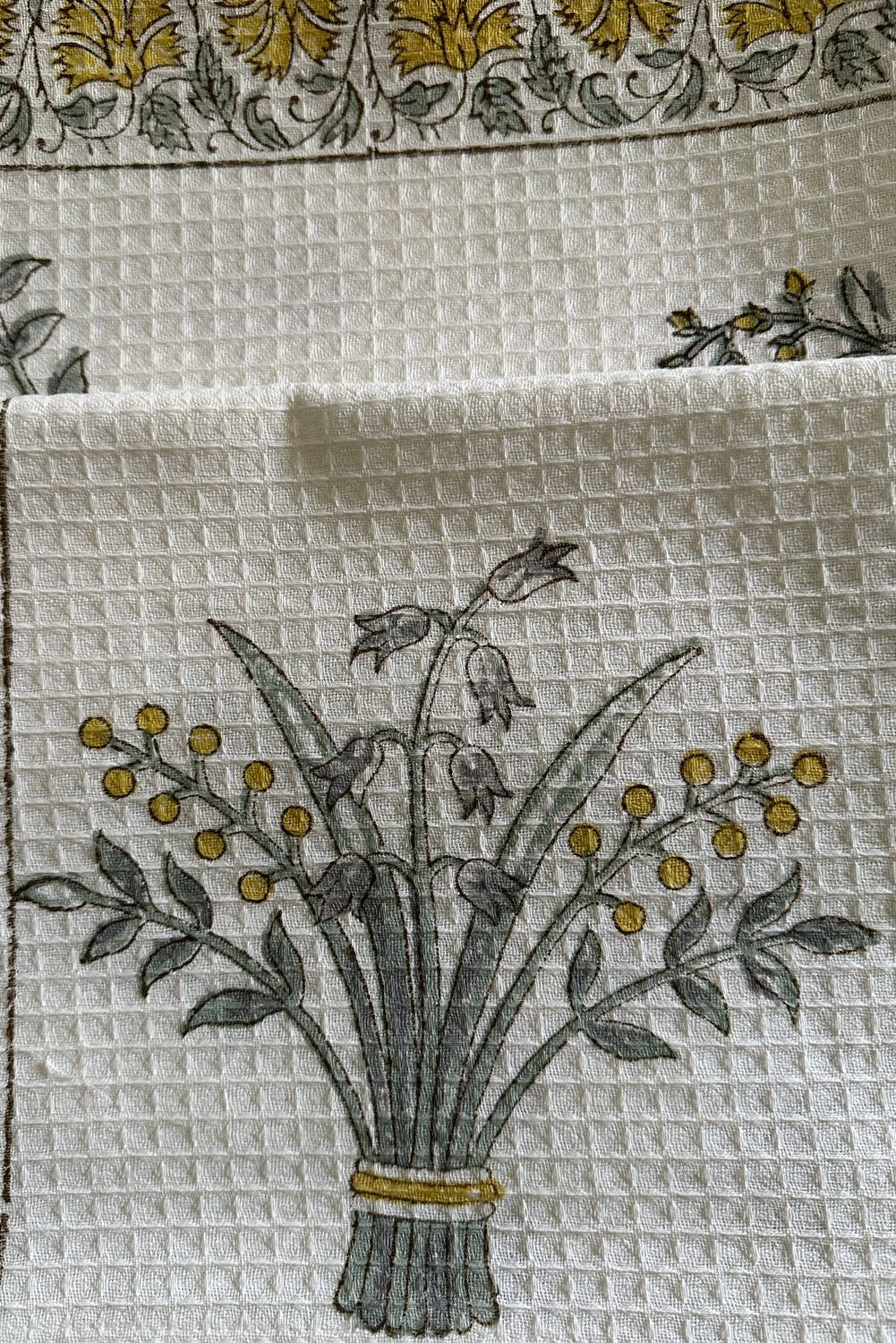 Decorative fabric with floral pattern and embroidered design on a white background