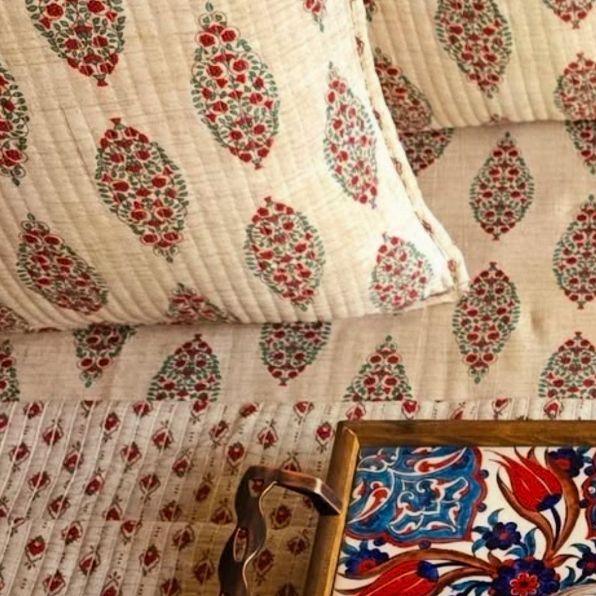 Decorative fabric with intricate patterns and a small framed artwork on a textured surface.