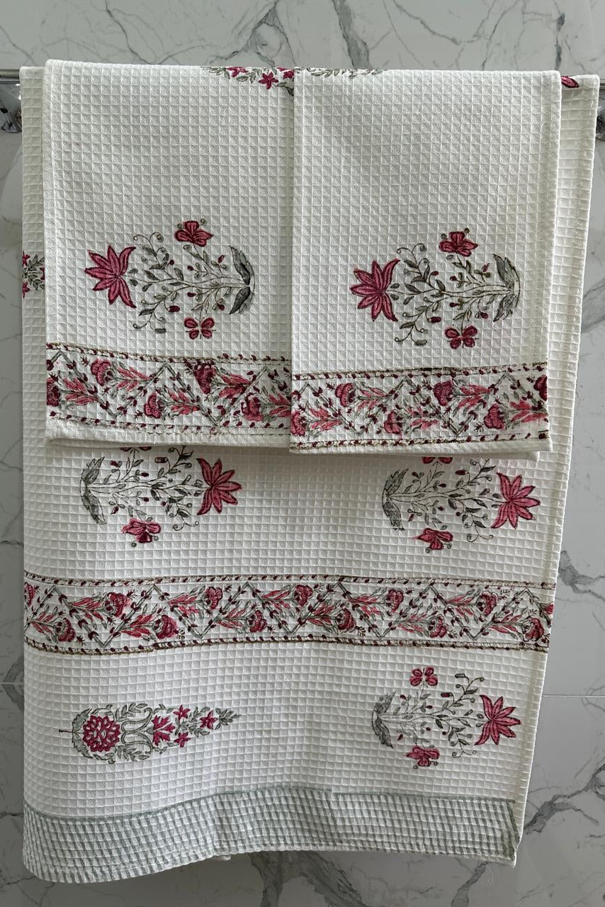 White towel with red floral patterns on a gray marble background