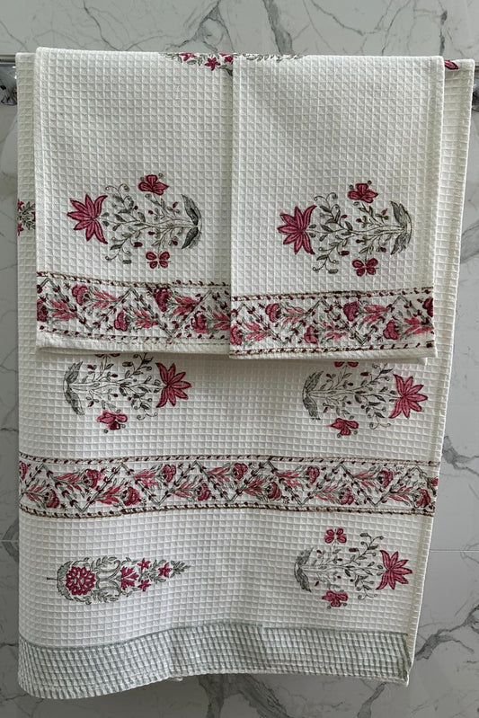 White towel with red floral patterns on a gray marble background