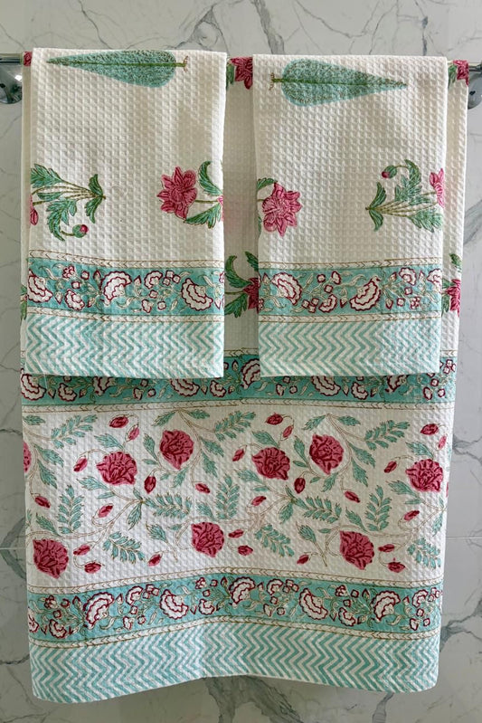 Decorative towel with floral pattern hanging on a rack against a marble background