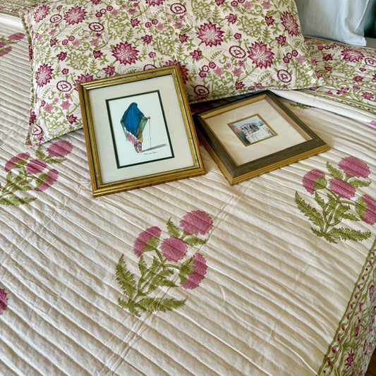 Floral-patterned bedspread with framed artwork on a bed